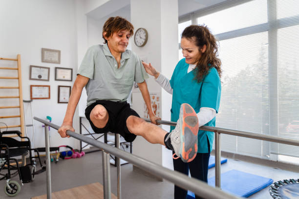 istock Young man uses parallel bars in a rehab center 1442318397