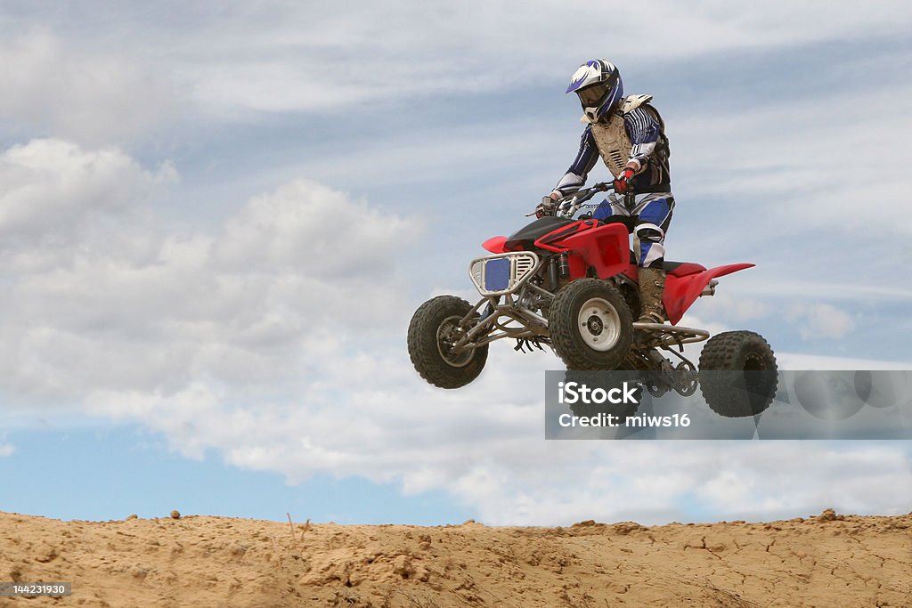 Four-Wheeler Jumping A 4-wheeler jumps on a  motocross track Quadbike Stock Photo