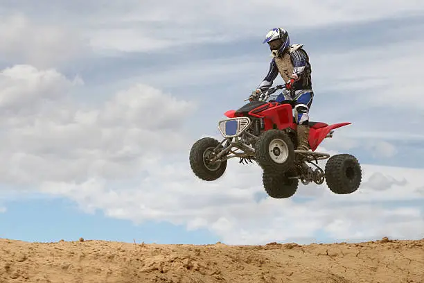 A 4-wheeler jumps on a  motocross track
