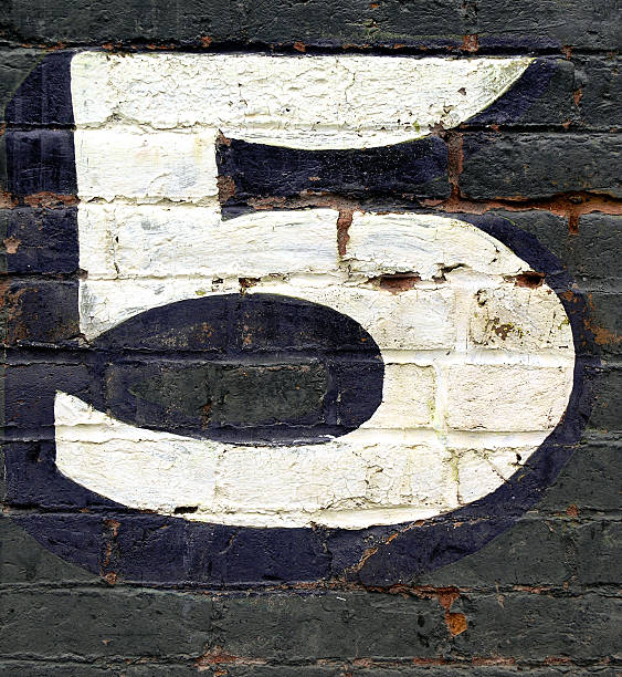 istock Black brick wall with the number five painted on it in white 144231932