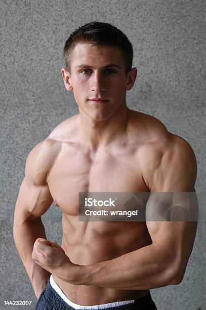 Młody Człowiek Mięśni Dostosowania Jego Biceps - zdjęcia stockowe i więcej obrazów Aktywny tryb życia - Aktywny tryb życia, Bez koszulki, Biceps
