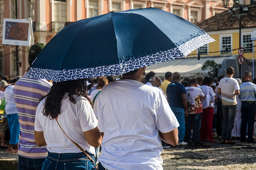 Salvador, Bahia, Brazil - May 26, 2016: Catholic worshipers with umbrellas are standing waiting for the Corpus Christ day ceremony in the city of Salvador, Bahia.