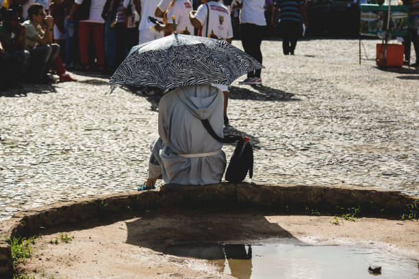 a catholic friar is sitting on the street during the mass of corpus christ - confessional nun imagens e fotografias de stock