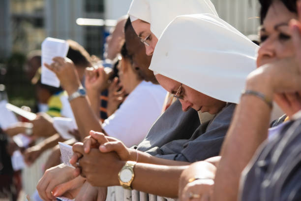 nuns and catholic faithful are praying during corpus christ mass - confessional nun catholic imagens e fotografias de stock