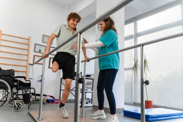 istock Young man uses parallel bars in a rehab center 1442321012