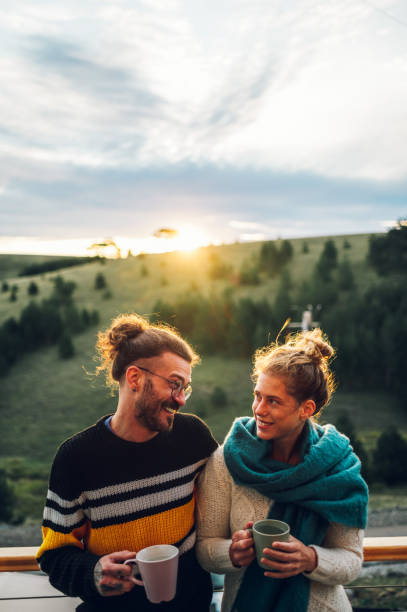istock Young couple drinking coffee or tea while standing on their balcony at sunrise 1442322345