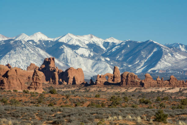 The La Sal mountains from Arches National Park Road Distant La Sal Mountains as seen from the middle of Arches National Park la sal mountains stock pictures, royalty-free photos & images