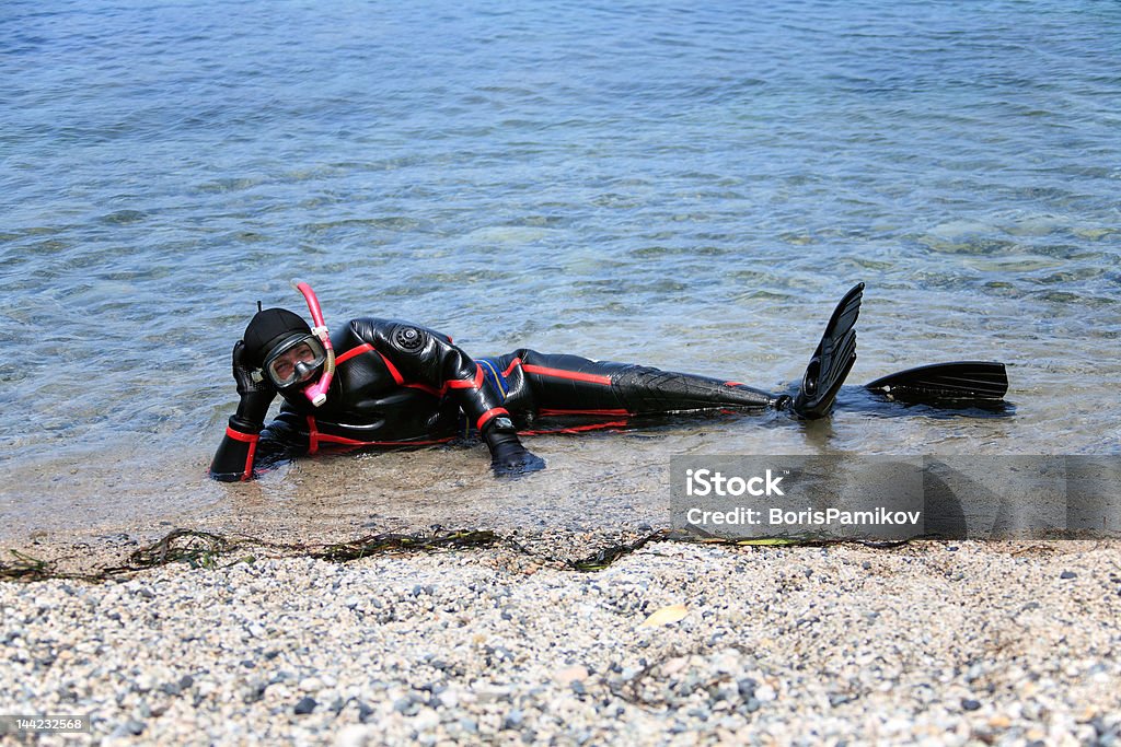 Hombre disfrazado de neopreno traje seco listo para practicar buceo con esnórquel - Foto de stock de Seco libre de derechos