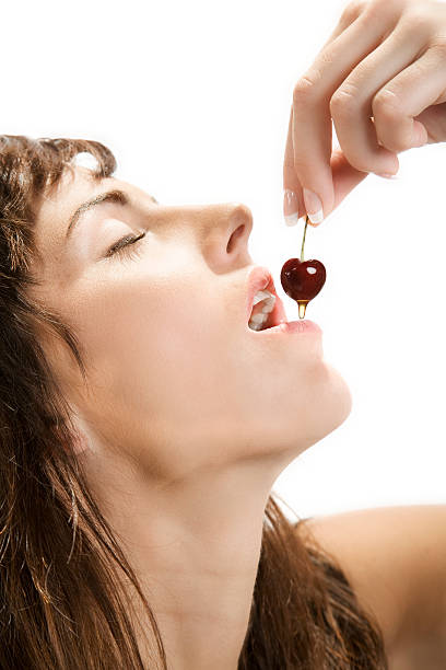 istock Beautiful young woman eating a cherry 144232580