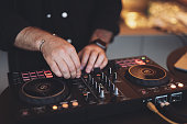 a DJ plays music on a controller at a party.
