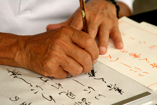 Man writing in Japanese Calligraphy.