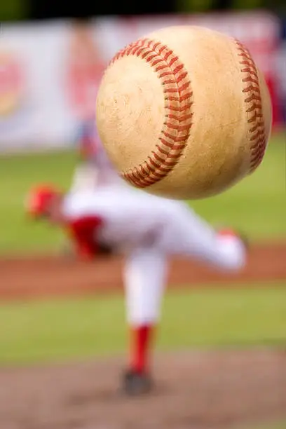 A baseball player pitching with spin on the ball. (motion blur on ball)