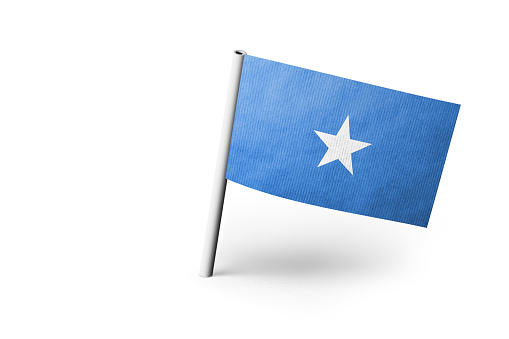 Small paper flag Somalia pinned. Isolated on white background. Horizontal orientation. Close up photography. Copy space.