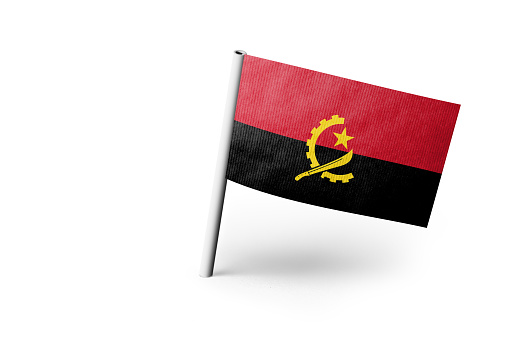 Small paper flag of Angola pinned. Isolated on white background. Horizontal orientation. Close up photography. Copy space.