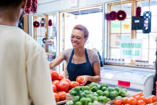 istock Female grocery store employee smiling 1442335080