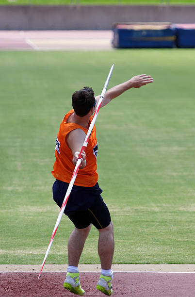 istock Athlete in orange singlet throwing javelin 144234806
