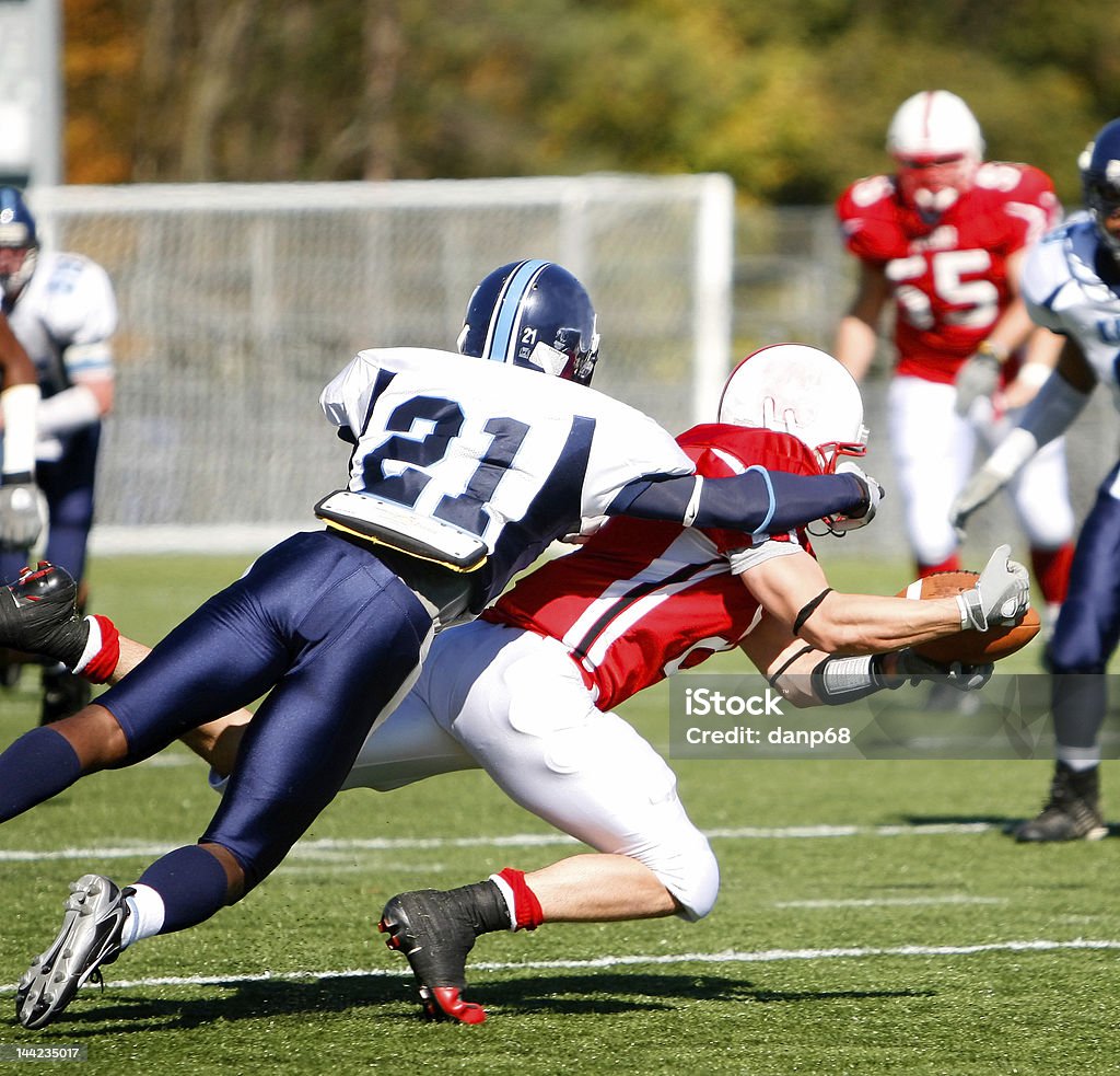 College Football - Catch and Tackle The running back dives for the first down with the defender on his back. American Football - Sport Stock Photo