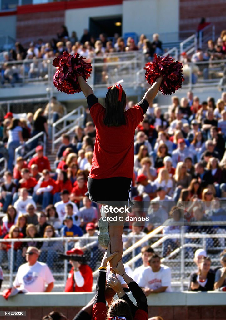 Autumn Football  - Cheerleader A football cheerleader is raised into the air infront of a large collegiate crowd. Cheerleader Stock Photo