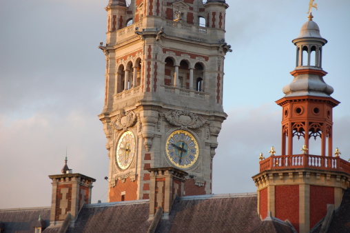 On the Grand-Place of Lille, the tower of the Chamber of Commerce and the Tower of the City Hall are watered by the last rays of sunshine of June