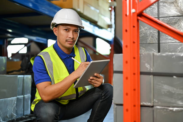istock Professional Asian male warehouse worker checking an inventory list on tablet, in warehouse. 1442364422