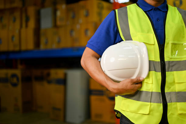 istock cropped, Asian male warehouse supervisor or worker in uniform holding a white hardhat 1442364523