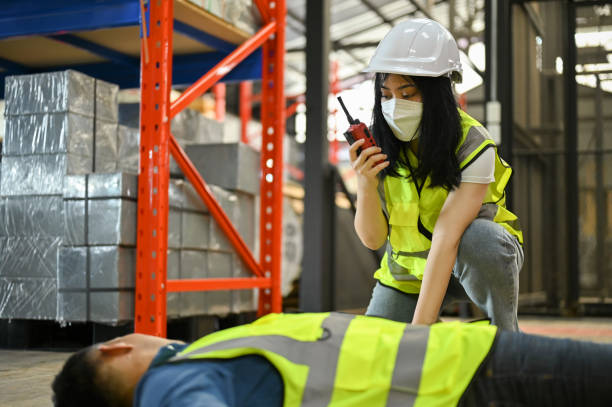 istock A female warehouse worker using a walkie-talkie, rescue an unconscious man. workplace accident 1442364771