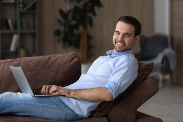 istock Happy young man hold notebook on laps look at camera 1442364788