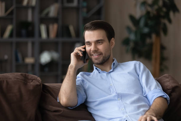 istock Smiling young man enjoy phone talk holding gadget at ear 1442364811
