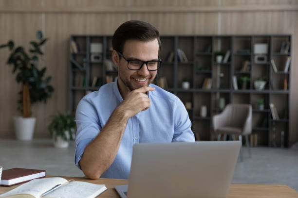 istock Smiling intelligent young man sit by laptop at scientific laboratory 1442364916