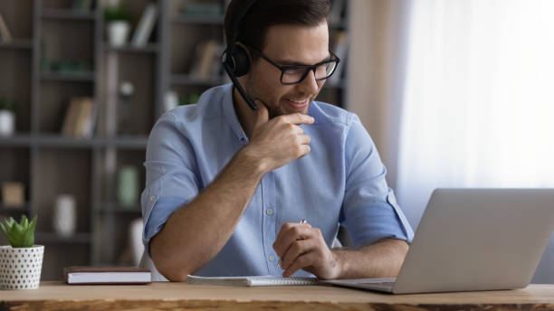 istock Young male student in headset confer with teacher online 1442364918