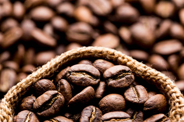 istock Roasted coffee beans in a cloth sack, on a dark background, close-up image, space for text 1442367562