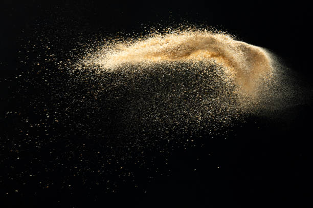 istock Sand flying explosion, Golden sand wave explode. Abstract sands cloud fly. Yellow colored sand splash throwing in Air. Black background Isolated selective focus, throwing motion Blur 1442368479