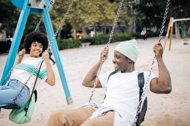 istock Happy couple having fun swinging on a playground. 1442371808