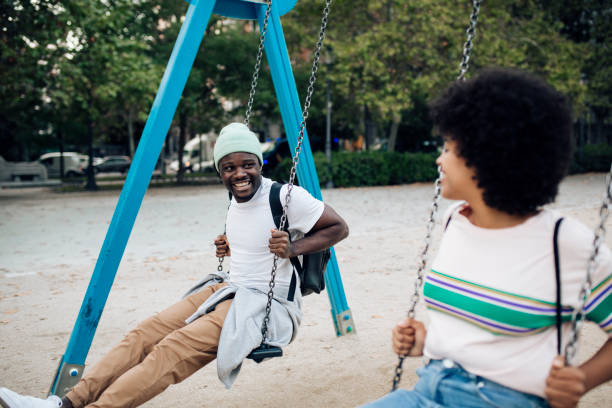 istock Happy couple having fun swinging on a playground. 1442371947