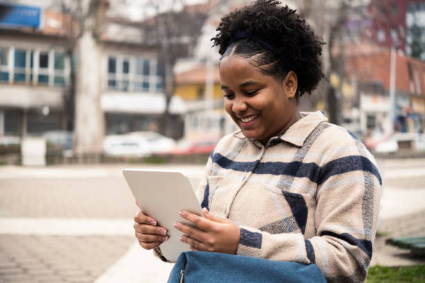 istock Beautiful Afro girl using tablet on the move 1442371979