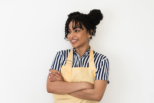 Studio portrait of a beautiful, happy young woman with apron