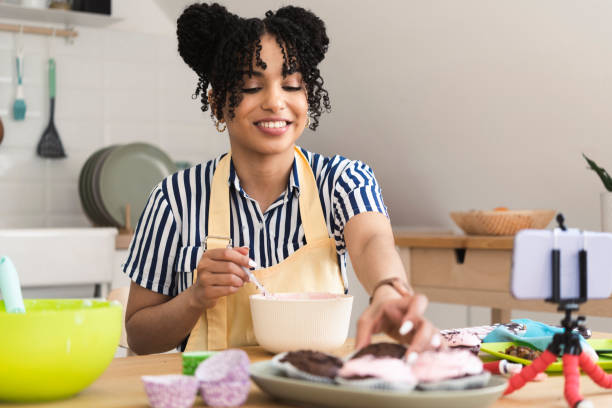 istock Portrait of a beautiful young woman filming a tutorial about baking and tasting a cookie dough 1442372109