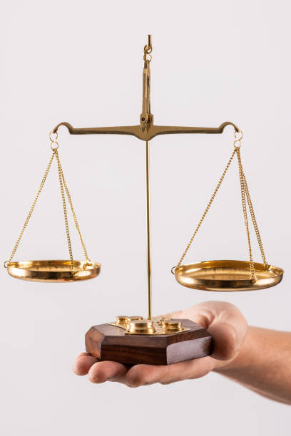 istock Golden scales with two bowls on a man's hand 1442372144