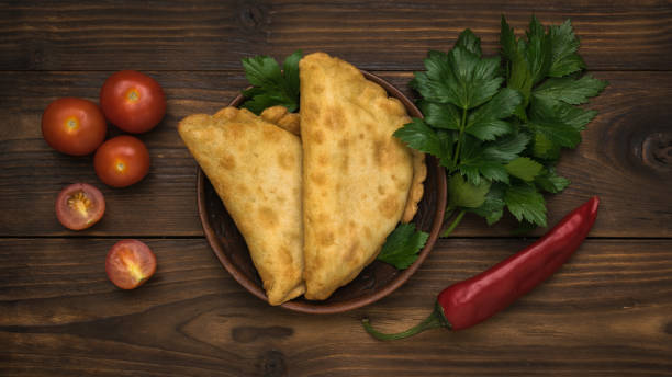 istock Two fresh pies with meat and herbs on a dark wooden table. 1442373852