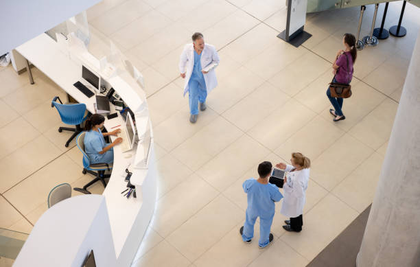 Doctors and nurses working at the hospital Group of doctors and nurses working at the hospital and walking around the entrance hall - healthcare and medicine concepts hospital interior looking down stock pictures, royalty-free photos & images