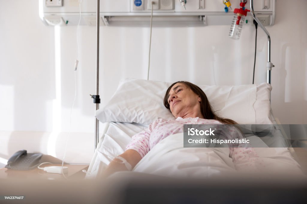 Sick woman lying in bed at the hospital Sick senior woman lying in bed at the hospital - healthcare and medicine concepts Hospice Stock Photo