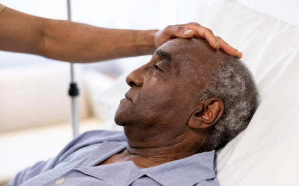Close-up on a sick senior adult being visited at the hospital by his son Close-up on a sick senior adult being visited at the hospital by his son - healthcare and medicine hospital depression sadness bed stock pictures, royalty-free photos & images