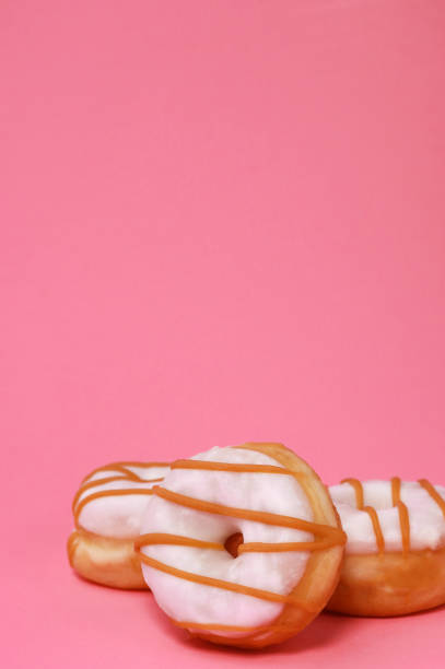 istock mini donuts with white glaze on pink background 1442383577
