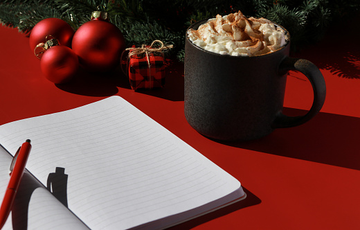 red Christmas composition with hot chocolate and note book for wish list