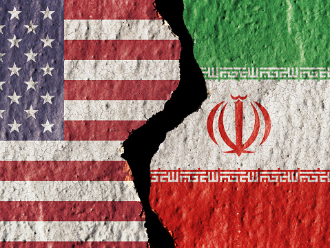 US Iran crisis, US IRan flags on cracked painted wall background