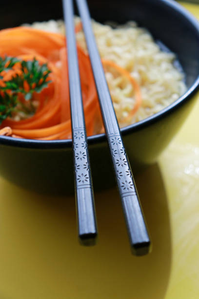 vegetarian ramen noodles with chopsticks pattern on yellow background