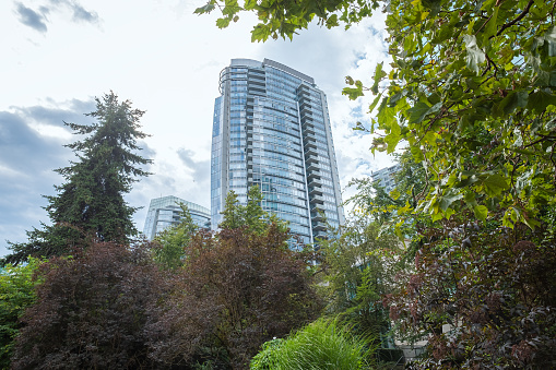Modern Green City - residential towers, tree lined public park at ground level.  Coal Harbour, Vancouver, British Columbia, Canada