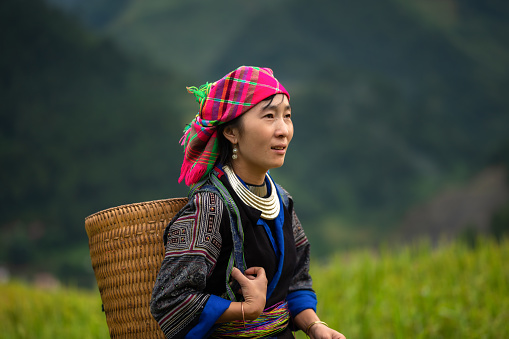 Hmong woman standing on rice terraces in Mu Cang Chai, Vietnam