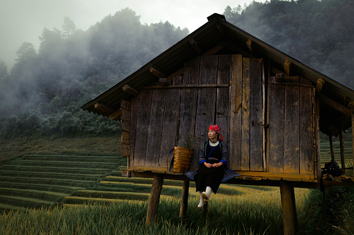 Hmong woman standing on rice terraces in Mu Cang Chai, Vietnam