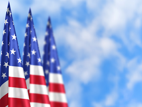 American flags on a flagpole on the blue sky